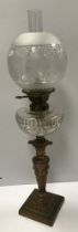 A late Victorian brass and cut glass oil lamp with acid etched globe,