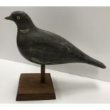 A 19th Century painted treenware pigeon decoy with glass eyes on a later oak pedestal stand 31.