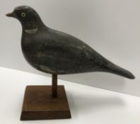 A 19th Century painted treenware pigeon decoy with glass eyes on a later oak pedestal stand 31.