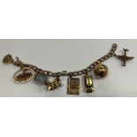 A 9 carat gold charm bracelet with padlock clasp and seven various charms, 16 cm long,