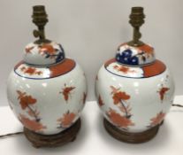 A pair of Japanese porcelain butterfly and flower decorated table lamps of ginger jar form in the