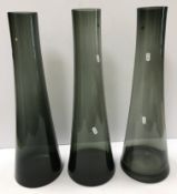 A set of three smoked glass tall vases of tapering form bearing labels to underside "Coro vase 60