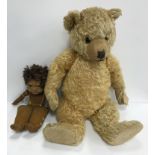 An early to mid 20th Century gold plush teddy bear with stitched nose and mouth and glass eyes,