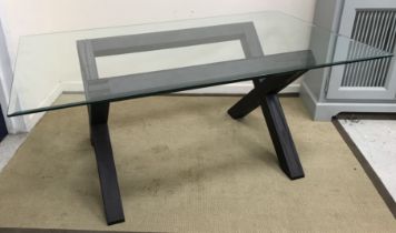 A modern rectangular dining table, the bevel edge glass top on a black ash X frame base, 182.