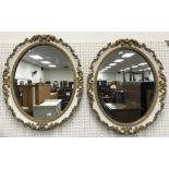 A pair of oval gilt gesso framed and cream painted wall mirrors in the Georgian style 52 cm x 62 cm