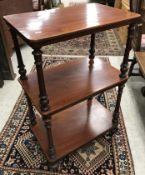 A Victorian mahogany three tier whatnot of rounded rectangular form, raised on turned,