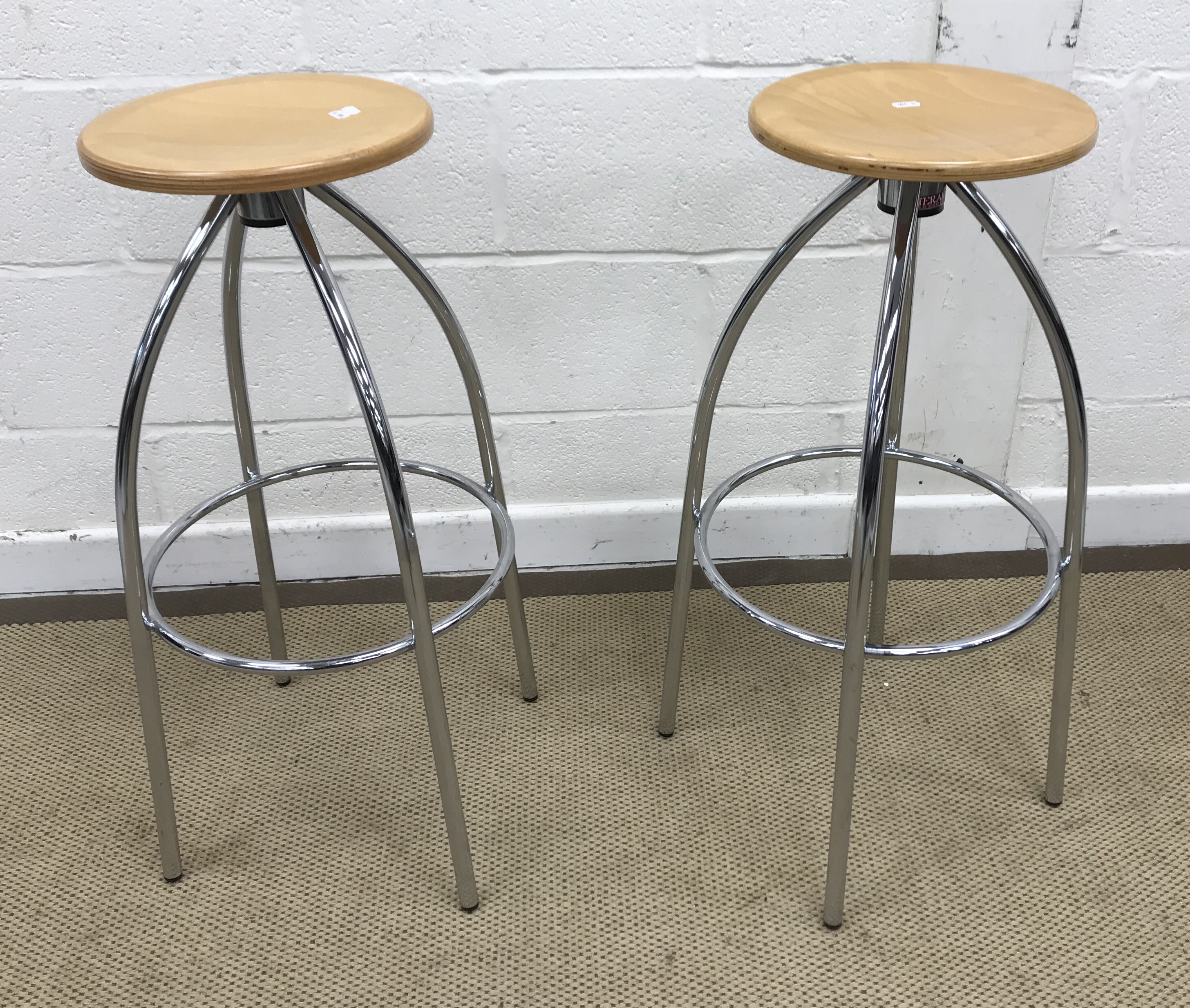 A pair of Merak plywood seated stools on chrome framed bases, 30 cm diameter x 78 cm high,
