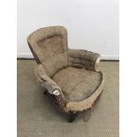 A Victorian scroll arm low salon chair on turned front legs to castors (for re-upholstery) and a