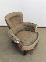 A Victorian scroll arm low salon chair on turned front legs to castors (for re-upholstery) and a