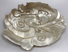 A circa 1900 Chinese carved shell dish decorated with dragon chasing a pearl,