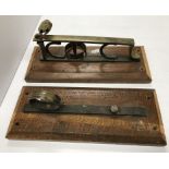 A pair of wall mounted brass gun racks with brass padlock, the oak mounts 32 cm x 12.