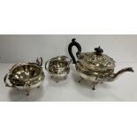 An Edwardian silver three piece tea set of squash form raised on four scroll feet comprising tea