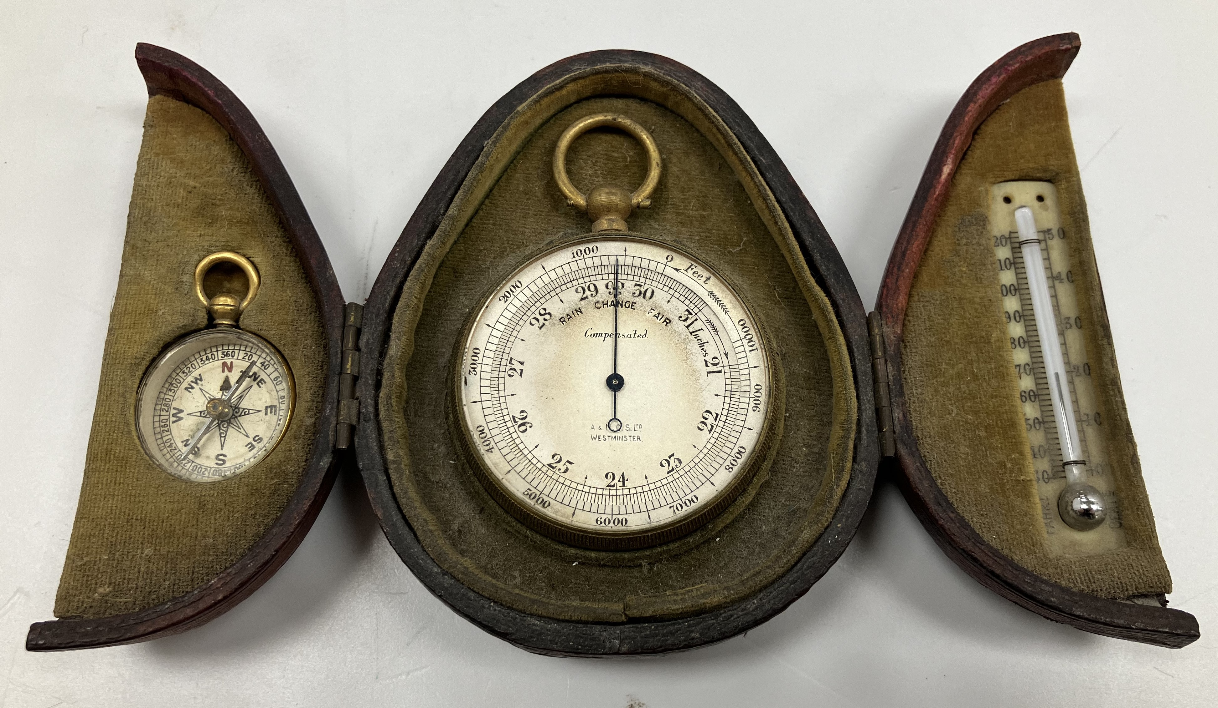 A circa 1900 gilt brass cased compensated barometer with silvered dial by The Army & Navy