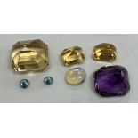 A collection of seven various cut stones including opal, amethyst, topaz, cubic zirconia,