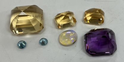 A collection of seven various cut stones including opal, amethyst, topaz, cubic zirconia,
