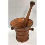 An orange painted cast iron pestle and mortar of large proportions, the mortar 27.