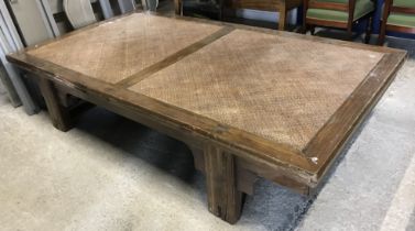 A 20th Century Indonesian teak and rattan low table / day bed, on square supports,