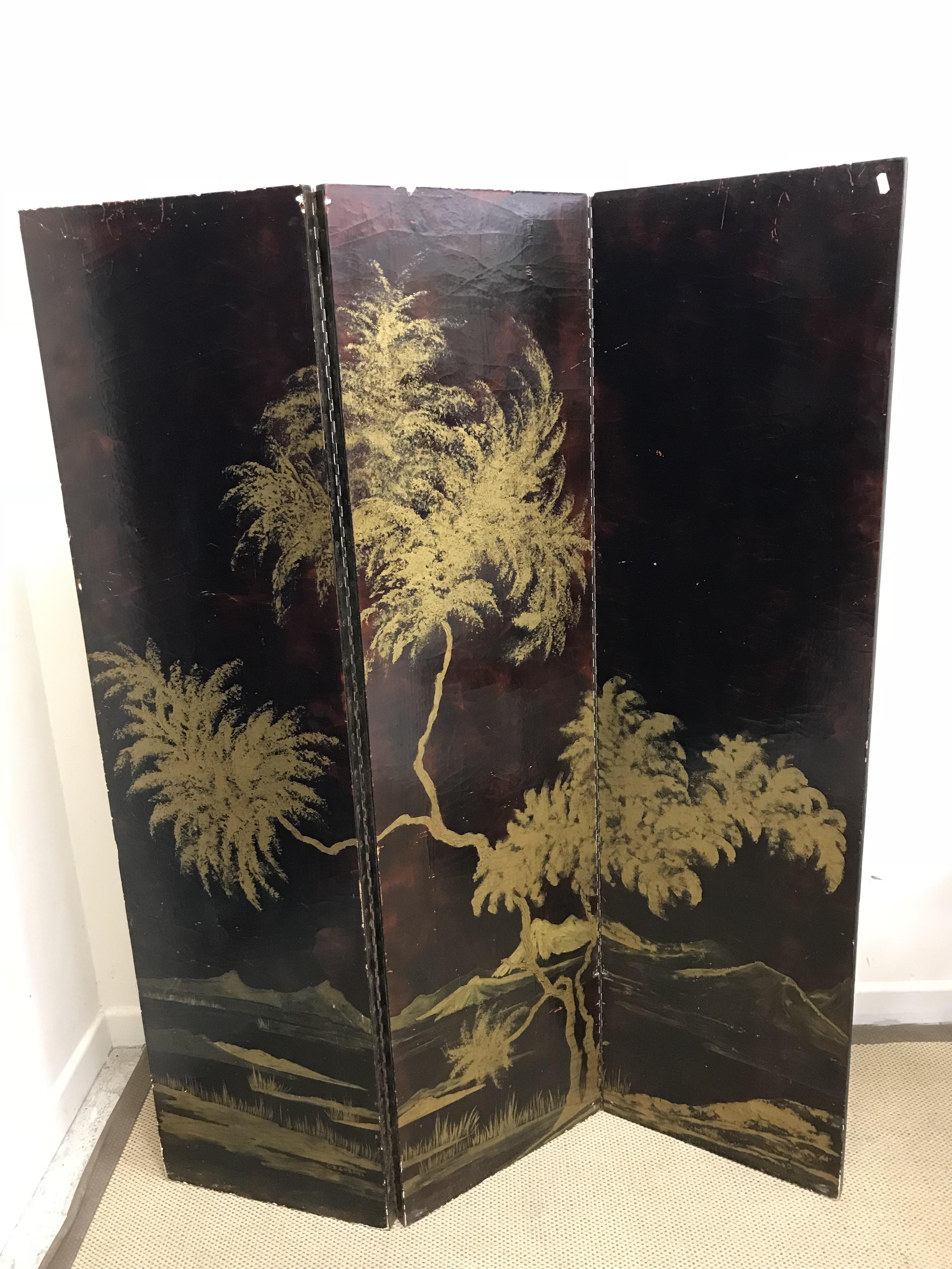 A 20th Century Chinese black lacquered and gilded three-fold screen with landscape decoration and