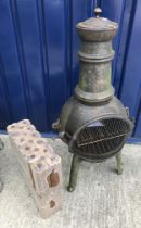 A small cast iron chiminea 95 cm high with two packets of briquettes