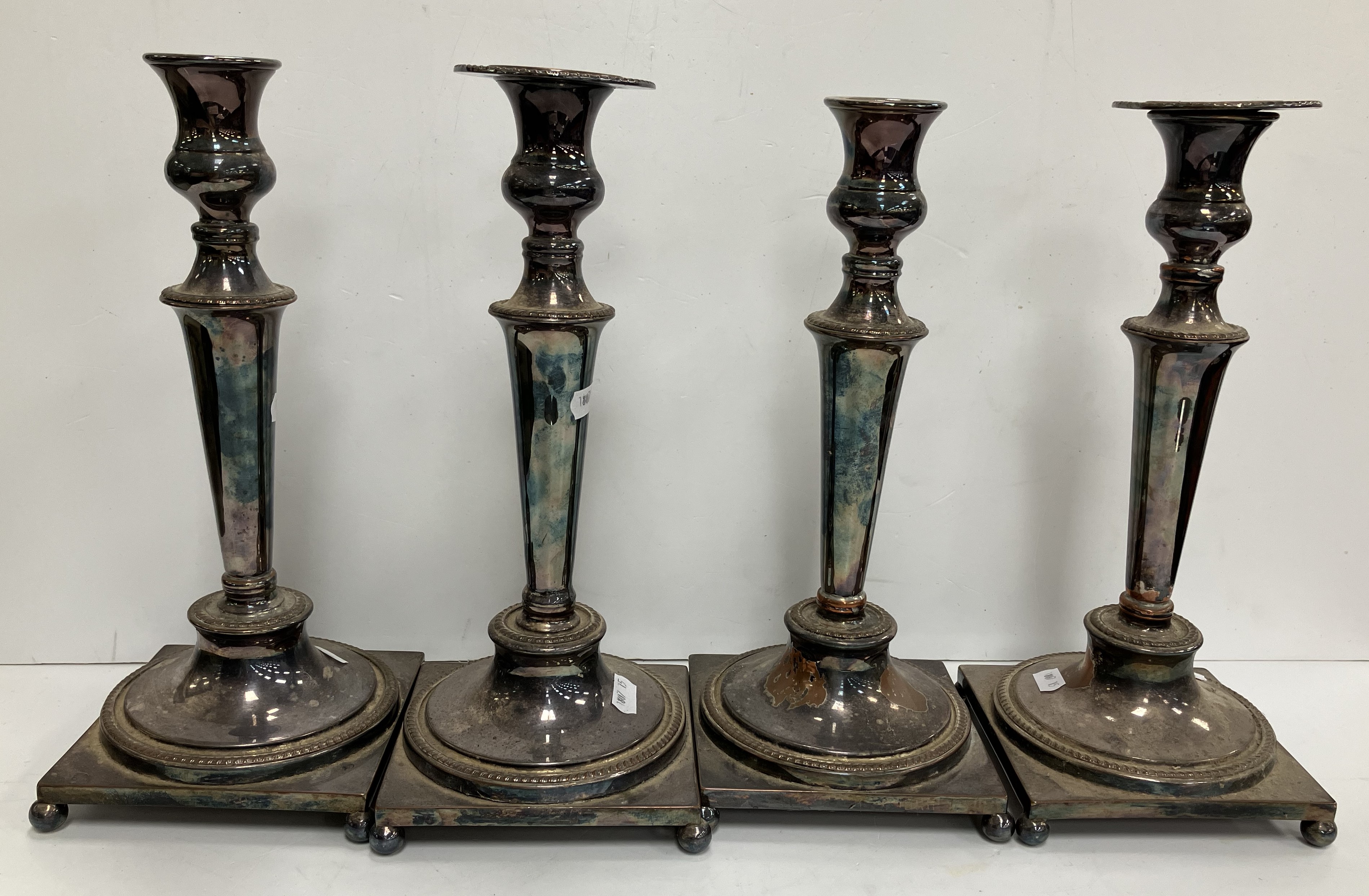 A set of four 19th Century plated on copper table candlesticks with gadrooned banded decoration