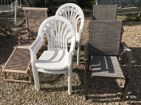 A slatted teak steamer chair, four white painted plastic chairs and,