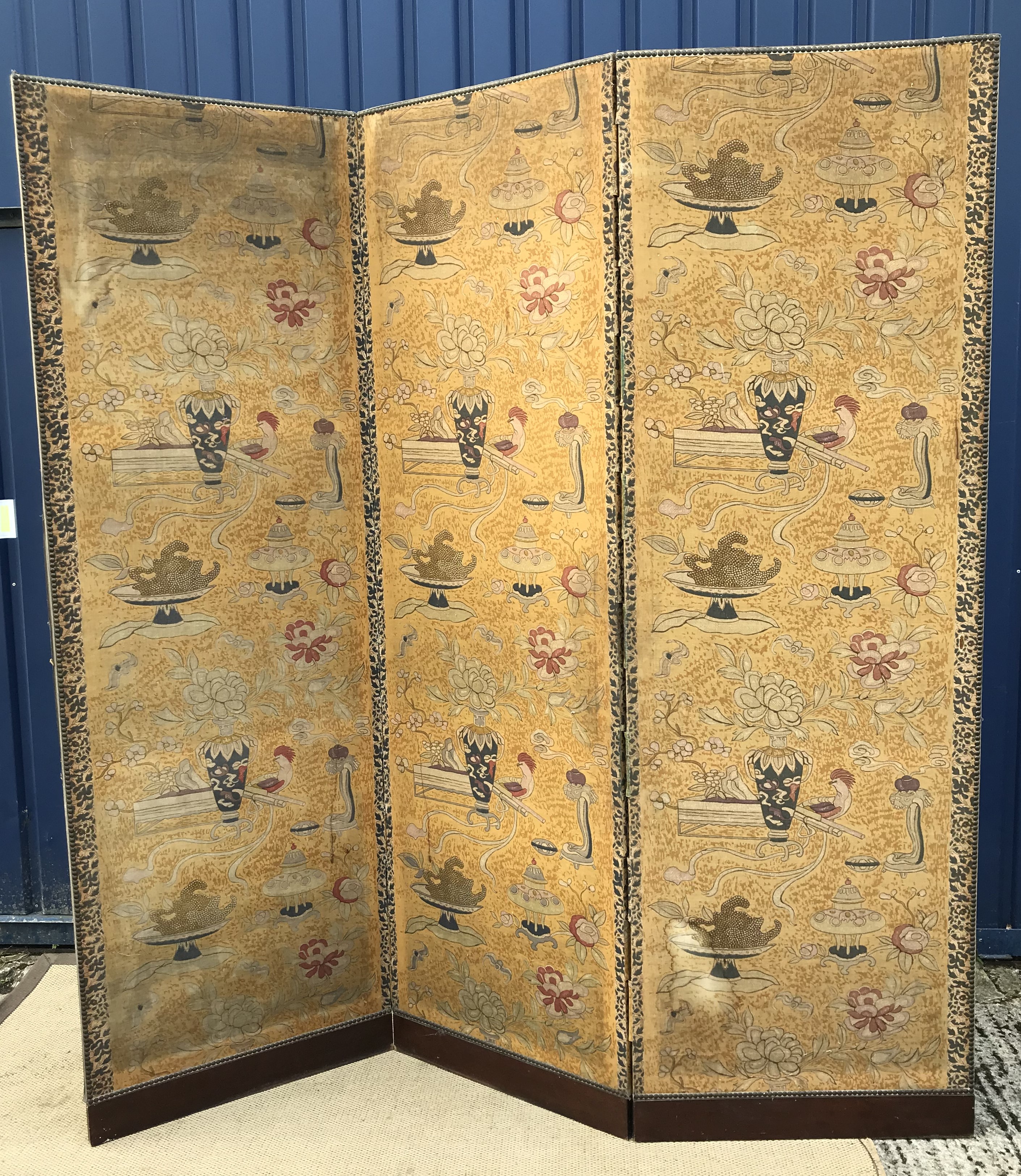 A late 19th / early 20th Century Chinese printed fabric covered three-fold screen decorated with