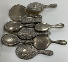 A silver backed three piece dressing set with two hairbrushes and mirror with beaded decoration,