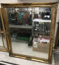 A modern rectangular swept gilt framed wall mirror with bevel edged plate in the 19th Century