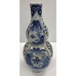 A Chinese blue and white double gourd shaped vase decorated with panels of figures in watery