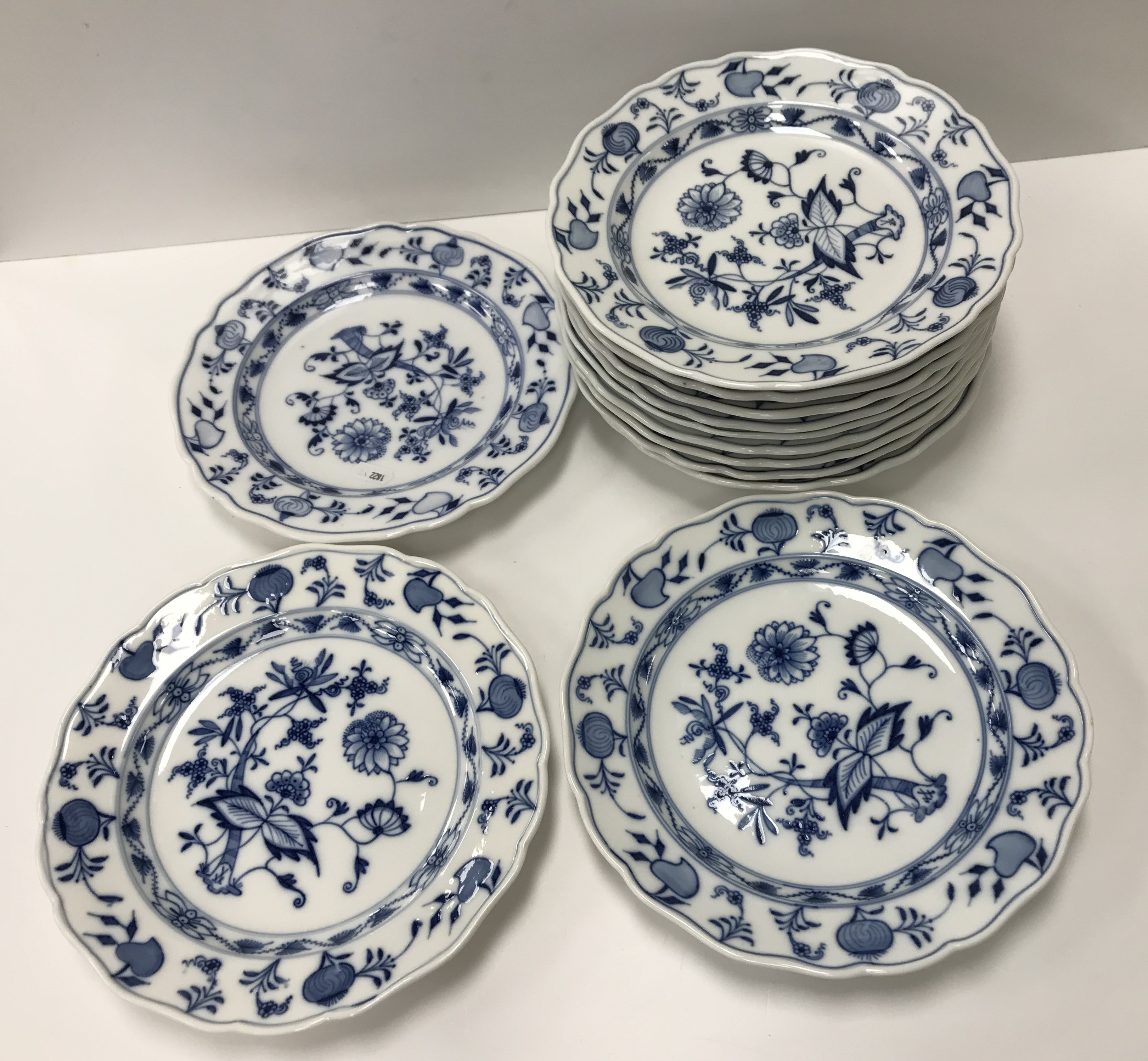A collection of twelve Meissen "Blue Onion" pattern plates bearing blue crossed swords marks to