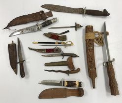 A collection of various daggers and miniature swords including a miniature ceremonial kukri,