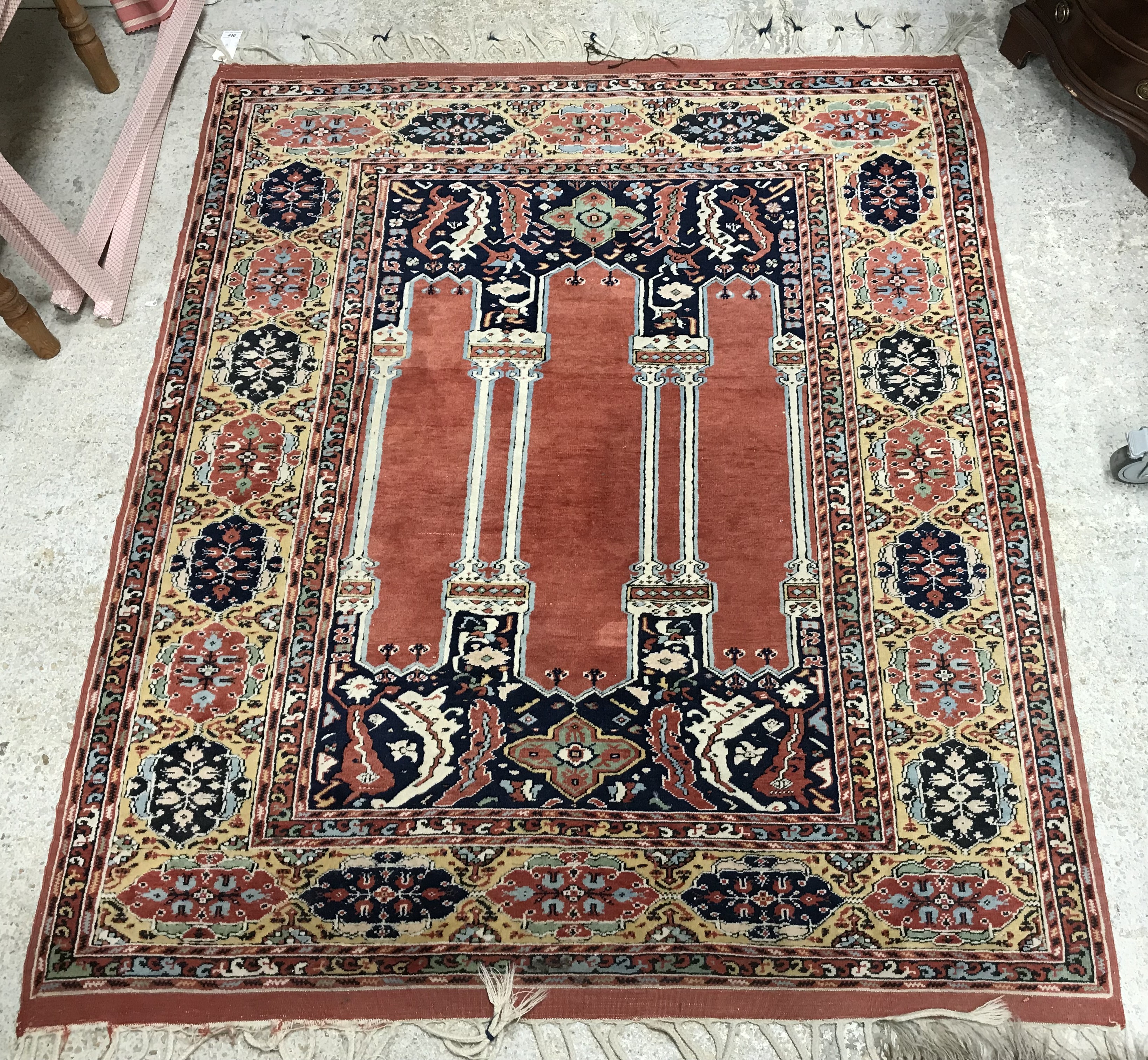 A Persian rug, the central panel set with three column design on a dark blue foliate ground,