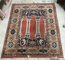 A Persian rug, the central panel set with three column design on a dark blue foliate ground,