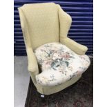 A 19th Century upholstered wing back scroll arm chair on cabriole front legs to pad feet,