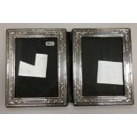 A late 20th Century silver double photograph frame with embossed decoration (by Nat Leslie Ltd,