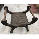 A late Victorian carved oak stool in the Gothic Revival taste,