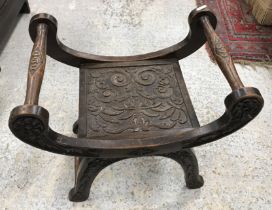 A late Victorian carved oak stool in the Gothic Revival taste,