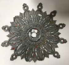 An 18th/19th Century lead ceiling rose of stylised foliate design bearing old red and white paint