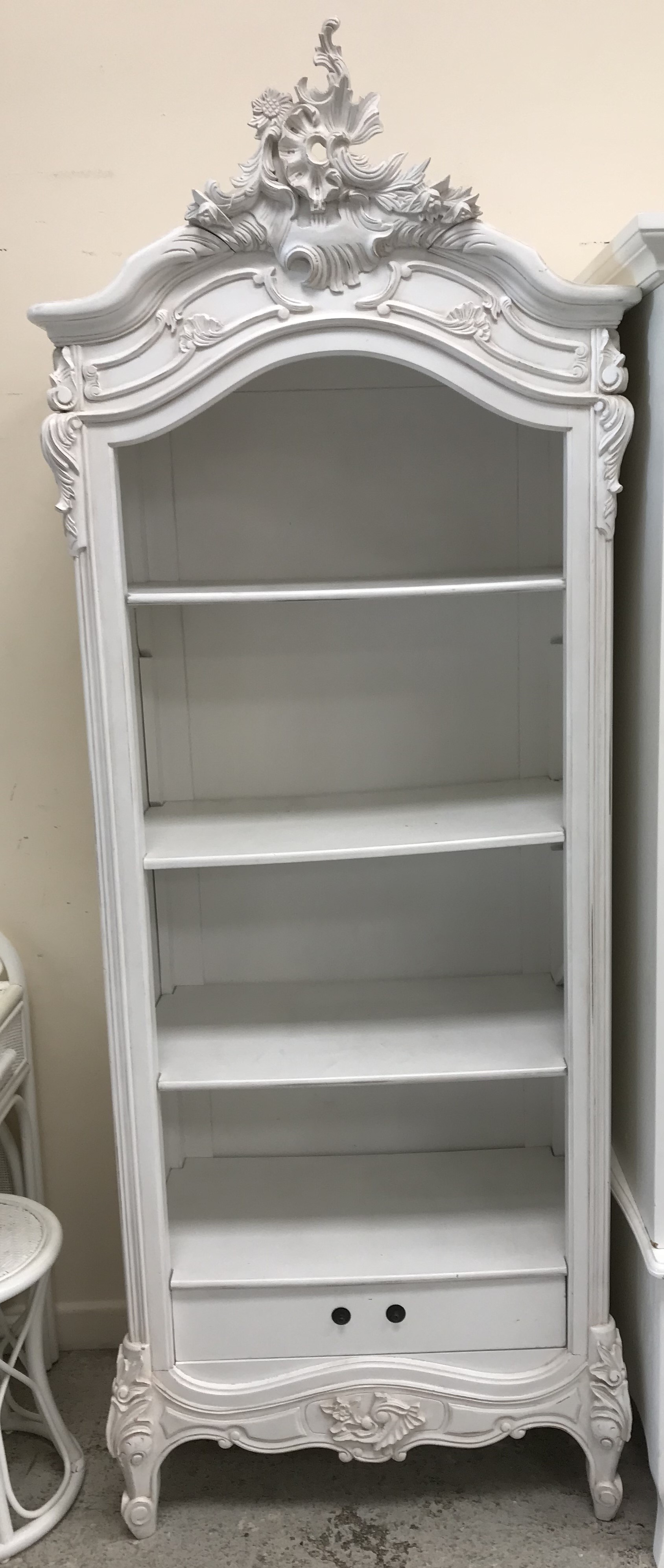 A modern white painted shelf unit in the Louis XV taste with adjustable shelving over a single