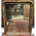 An early 20th Century gilt framed rounded rectangular wall mirror with plain plate,