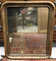 An early 20th Century gilt framed rounded rectangular wall mirror with plain plate,