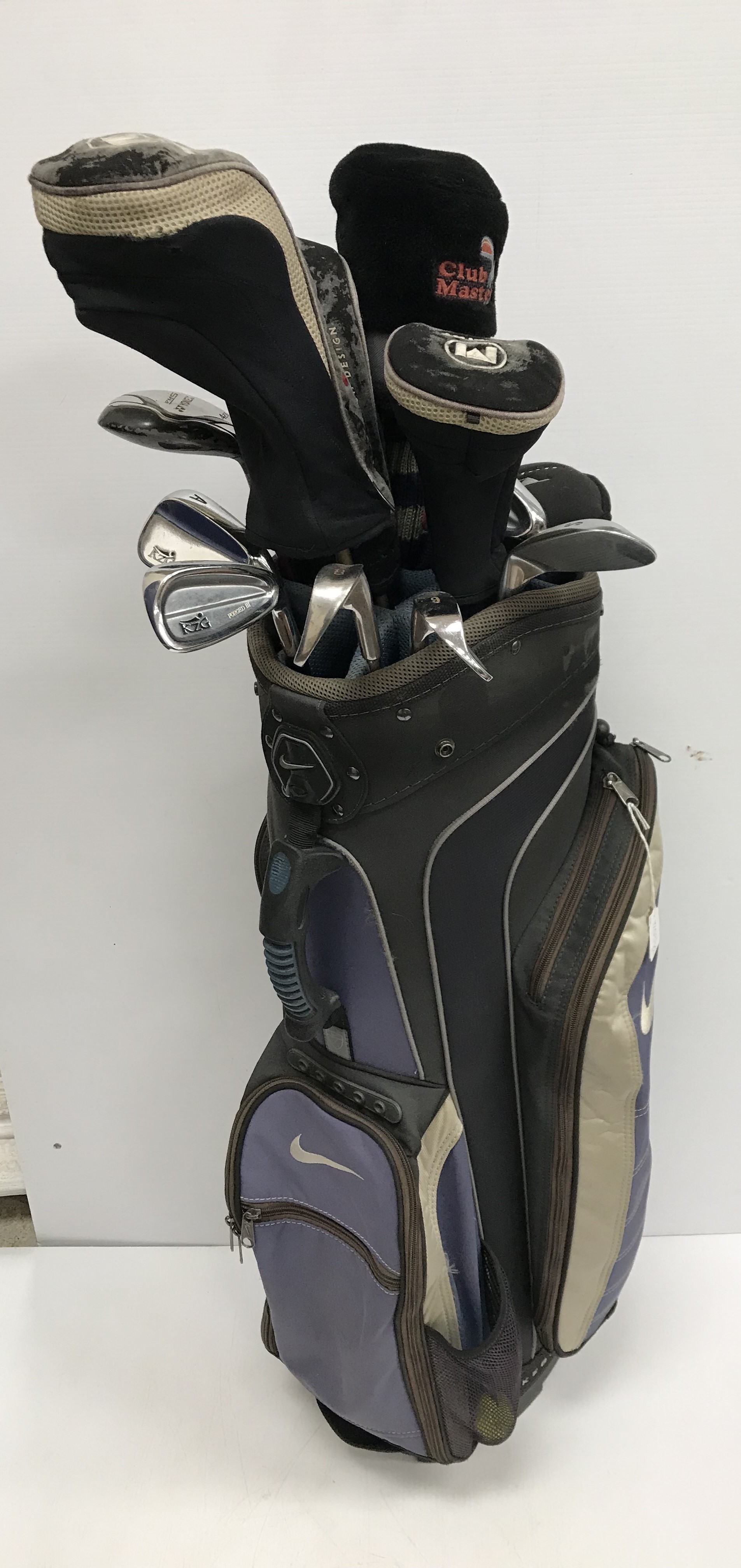 A canvas golf bag and contents of five various golf woods, seven various irons and two putters, etc.