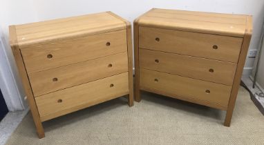 A pair of modern oak three drawer chests, the plain top with plank detail and rounded top corners,