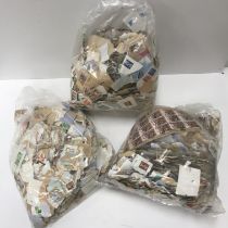 A box containing three plastic bags of various unmounted British and World stamps