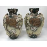 A pair of early 20th Century Japanese satsuma ware vases with relief work bird and knot decorated