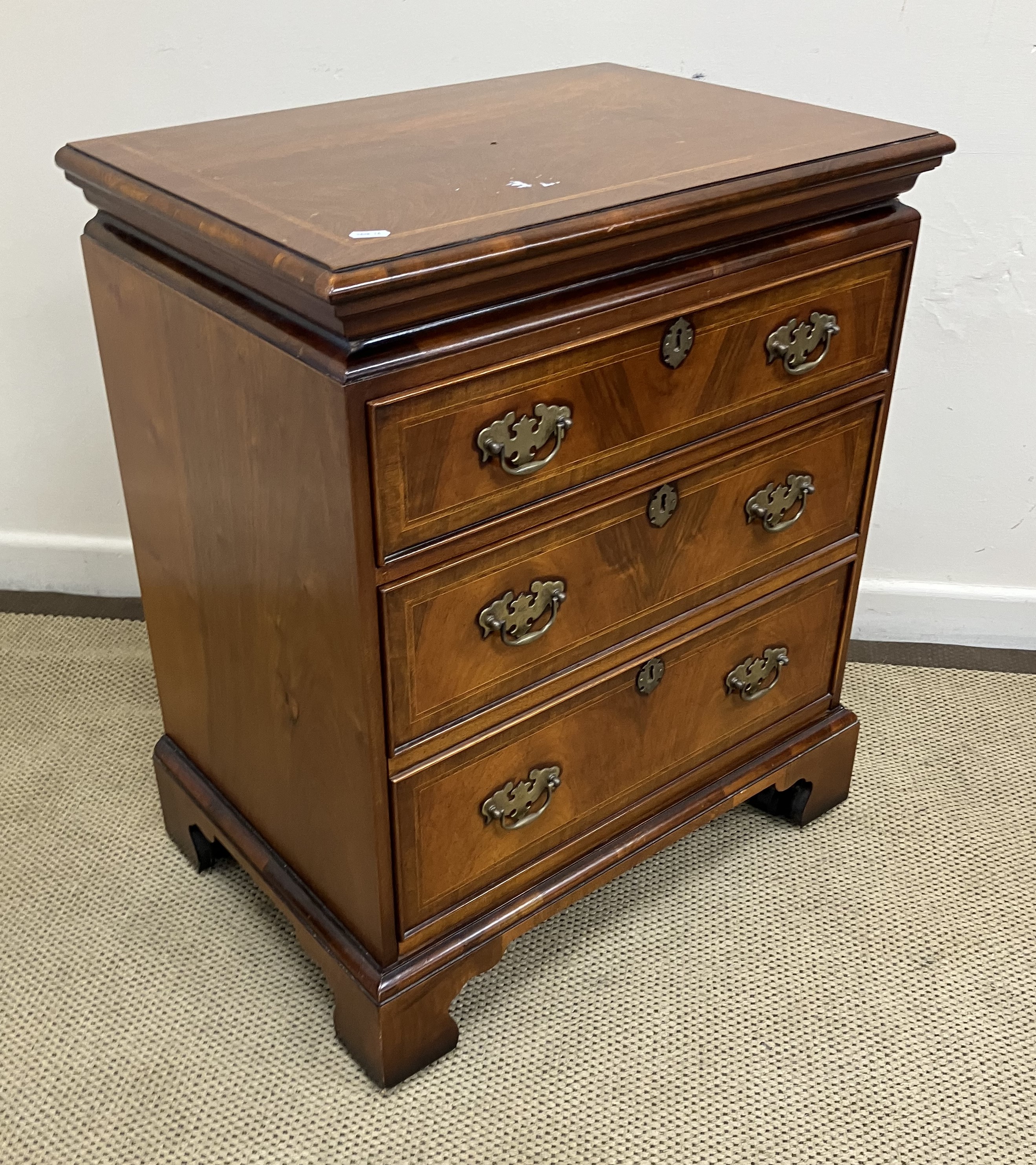 A modern reproduction walnut and feather-banded chest in the early 18th Century style,