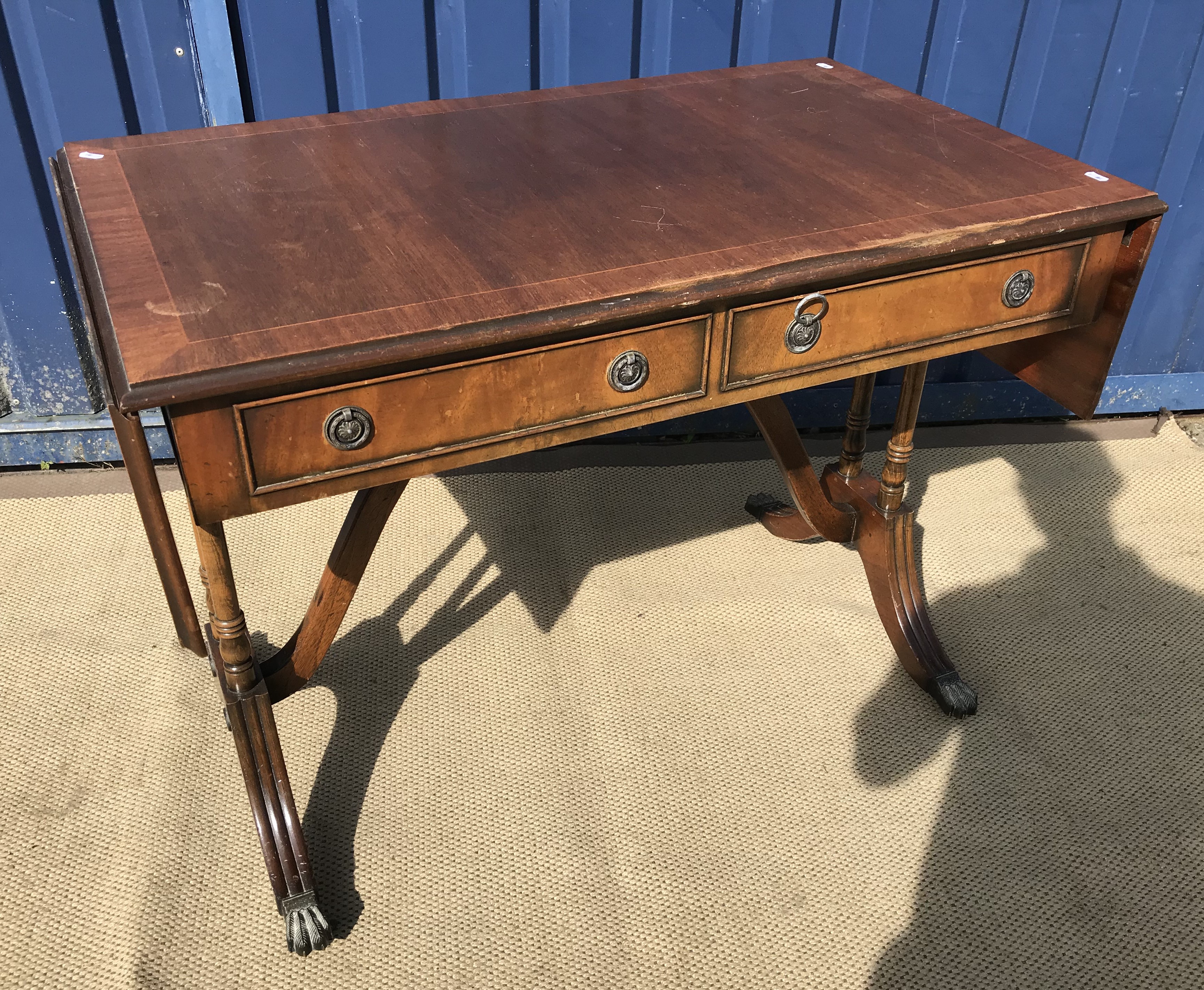 A modern reproduction mahogany and cross-banded sofa table in the Regency style and a modern