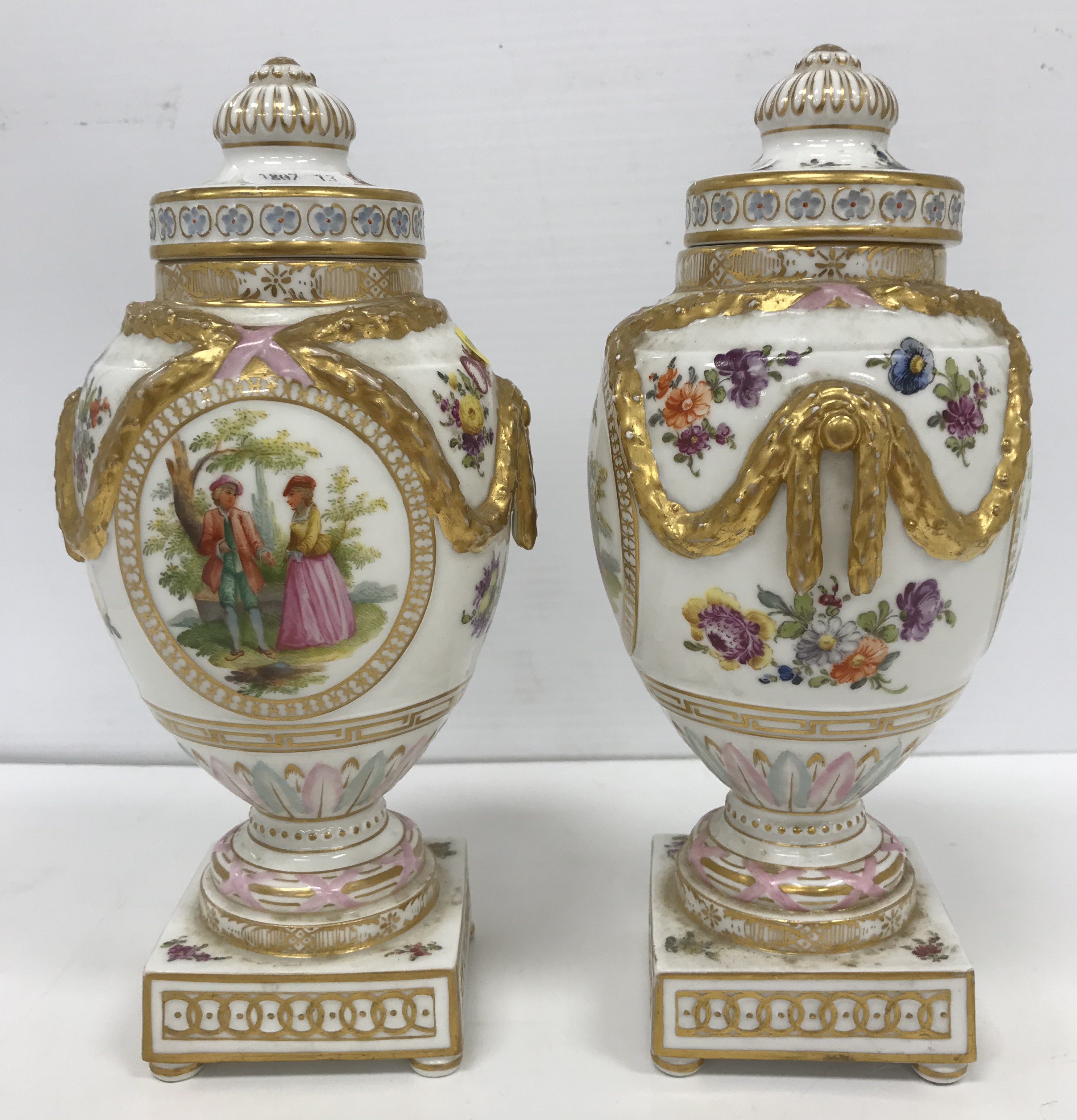 A pair of 19th Century Berlin porcelain urns and covers,