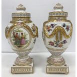 A pair of 19th Century Berlin porcelain urns and covers,