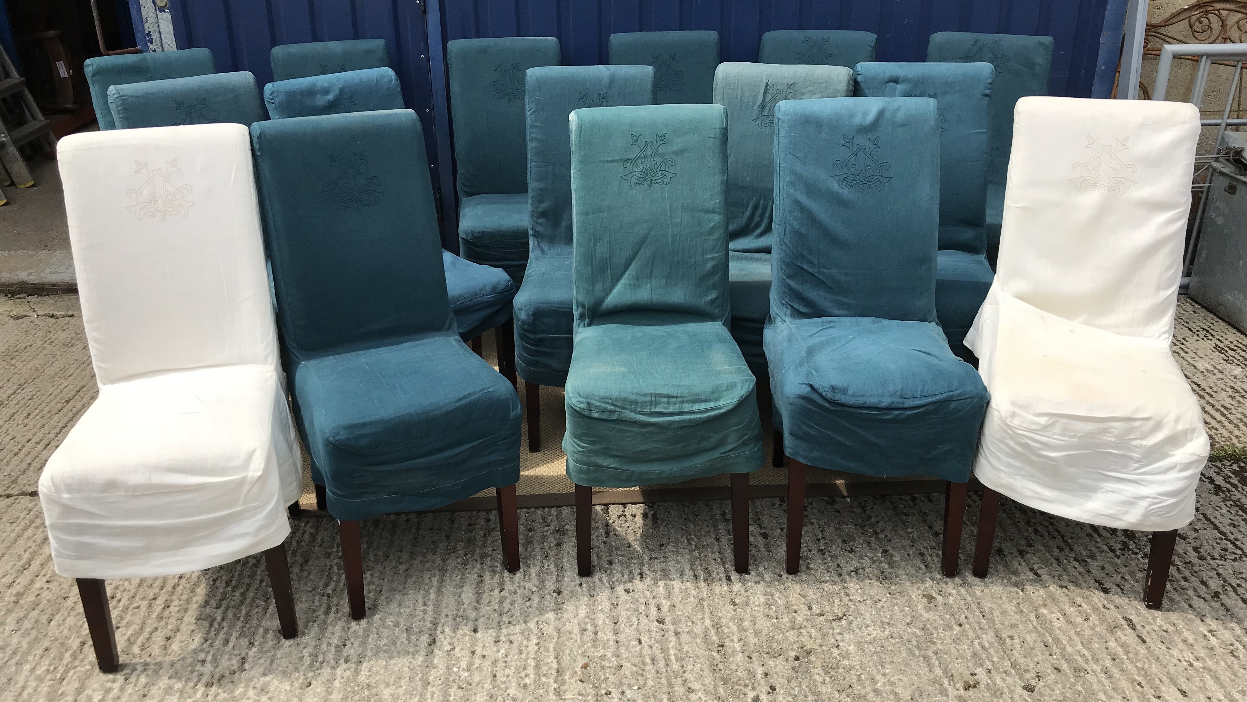 A set of twelve OKA high back upholstered dining chairs on square tapered legs with green linen